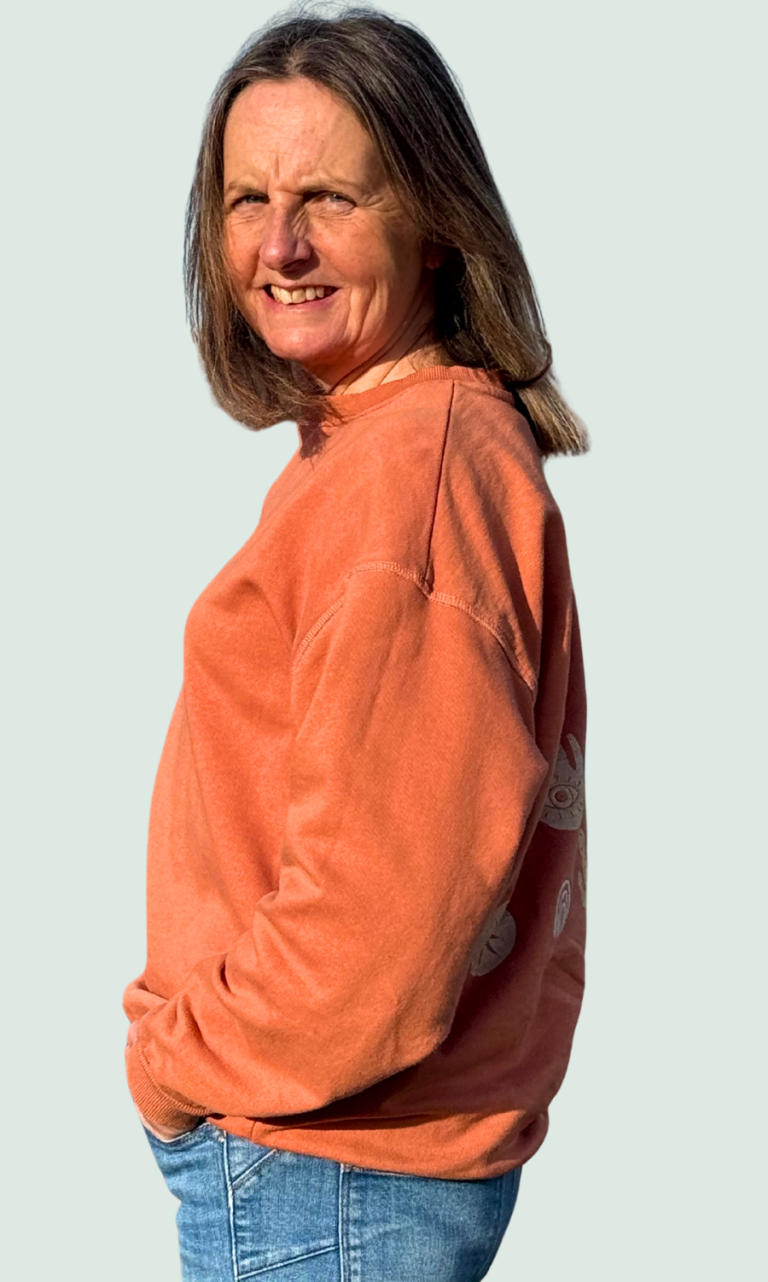 Jayne Mullis A photo of Jayne Mullis wearing an orange hoody and a pair of jeans, looking casual with her hands in pockets